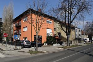 Apartment Check In Zagreb Maksimir-free parking في زغرب: مبنى على زاوية شارع فيه سيارات تقف امامه