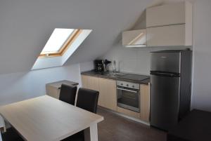 a kitchen with a table and a stainless steel refrigerator at Apartments Nostro in Omiš