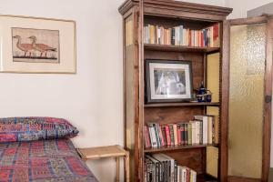 une chambre avec une étagère remplie de livres dans l'établissement Studio Borgo Colonne, à Parme