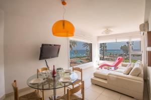 a living room with a couch and a table at Pallinio Fig Tree Bay Apartments in Protaras