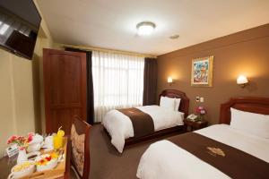 Un pat sau paturi într-o cameră la Hotel Mabey Cusco