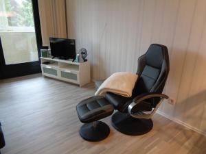 a black chair in a living room with a television at Schönberger Strand (Holm) in Schönberg in Holstein