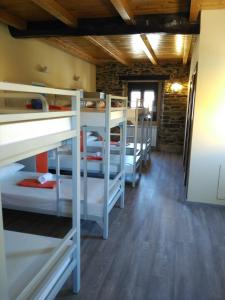 ein Zimmer mit einem Haufen Etagenbetten in der Unterkunft Albergue Pension Porta Santa in Baleira