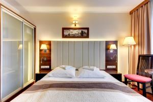 a hotel room with a large bed with two pillows at Amber Hotel in Gdańsk