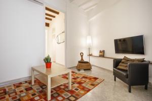 een woonkamer met een bank, een tafel en een tv bij Barcelona Just Like Home in Barcelona