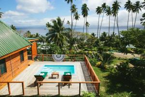 a house with a swimming pool next to the ocean at Daku Resort in Savusavu