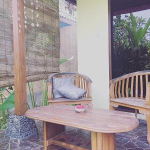 una mesa de madera y sillas en un patio con mesa en Pondok Balian, en Selemadeg