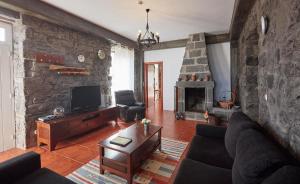 a living room with a couch and a fireplace at Casa do Vale do Sossego in Capelas