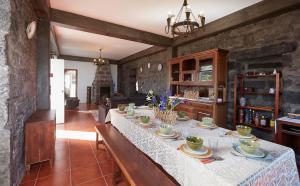 a dining room with a table with dishes on it at Casa do Vale do Sossego in Capelas