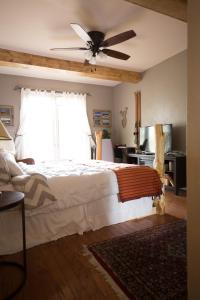 Schlafzimmer mit einem Bett und einem Deckenventilator in der Unterkunft Pueblo Canyon Inn in Los Alamos