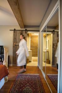 a woman walking through a living room with a rug at Pueblo Canyon Inn in Los Alamos