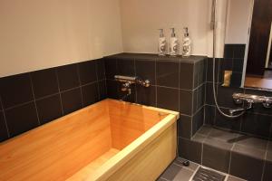La salle de bains est pourvue d'une baignoire et de parquet. dans l'établissement Kiyomizu Birodo-an, à Kyoto