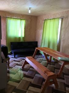 a living room with a wooden table and a couch at Cabañas a Cuadras Laguna Quillón in Quillón