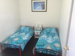 Lazy Dayz Shellharbour في شلهاربور: غرفة صغيرة بسريرين وطاولة