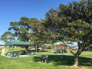 a park with a picnic shelter and a playground at Lazy Dayz Shellharbour in Shellharbour