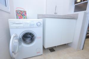 uma máquina de lavar e secar roupa branca numa cozinha branca em Aquarelle Ingleses em Florianópolis
