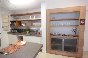 a kitchen with a counter and a sink and shelves at Aquarelle Ingleses in Florianópolis