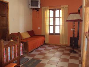 a bedroom with a bed and a tv and a window at Cabañas del Molle in Valle Hermoso