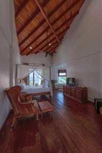 a large bedroom with a bed and a wooden floor at Cardamon Hotel Nilaveli in Nilaveli