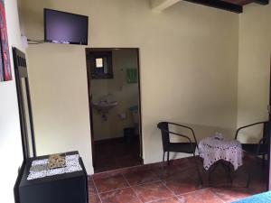 una stanza con tavolo e sedie e una televisione sul muro di Posada Quinta Alejandra a Bernal