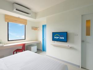 a bedroom with a bed and a tv on a wall at Hop Inn Krabi in Krabi