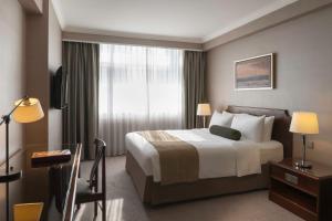 a hotel room with a bed and a window at Marco Polo Hongkong Hotel in Hong Kong