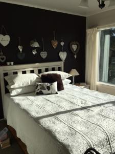 een slaapkamer met een groot bed met een zwarte muur bij Beach Side B & B in Auckland