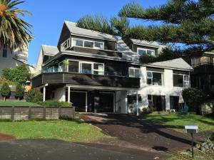 ein Haus mit einer Palme davor in der Unterkunft Beach Side B & B in Auckland