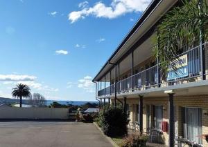 a building with a balcony on the side of it at Coastal Comfort Motel in Narooma