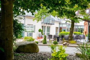 a house with tables and chairs in front of it at Sporthotel Fuchsbachtal in Barsinghausen