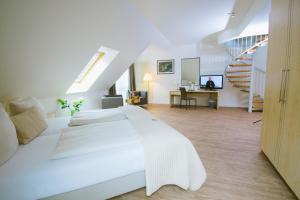 a white bedroom with a large bed and a staircase at Sporthotel Fuchsbachtal in Barsinghausen