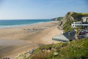a view of a beach with a house and the ocean at Waves Apartments in Newquay
