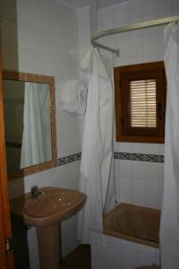 a bathroom with a sink and a shower and a mirror at Hostal Rural Las Terrazas de la Alpujarra in Bubión