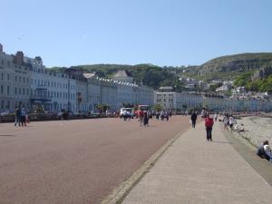a group of people walking down a street with buildings at THE TREVONE, Llandudno in Llandudno