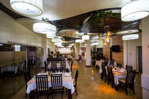 a dining room with tables and chairs and lights at Hotel Grandis Apulum in Mioveni