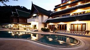 a house with a swimming pool in front of a building at Prince Edouard Apartments & Resort Patong Beach Phuket in Patong Beach