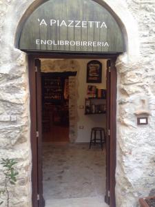 a door to a wine shop in a stone building at Residenza d'Epoca Borgodifiume in Fiumefreddo Bruzio