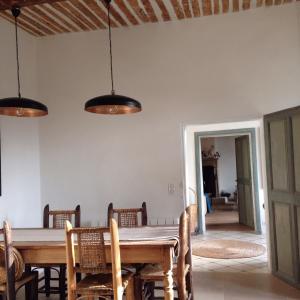 uma sala de jantar com uma mesa de madeira e cadeiras em La Calade em Lourmarin