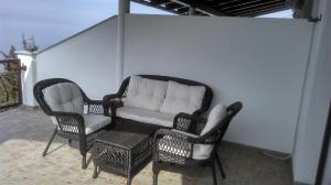 a couch and two chairs on a patio at Delfin Apartments in Sveti Juraj
