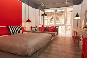 ナポリにあるToledo Loftの赤い壁のベッドルーム1室(大型ベッド1台付)