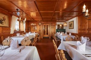 a dining room with white tables and chairs at Hotel Adler in Oberstaufen