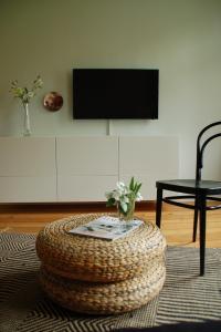 a living room with a table and a tv on a wall at SCHÖNER WOHNEN IM DENKMAL - großzügig geschnitten, kostenfreies WLAN in Leipzig