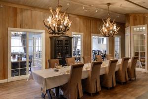 uma grande sala de jantar com uma mesa longa e lustres em Hafjell Hotell em Hafjell
