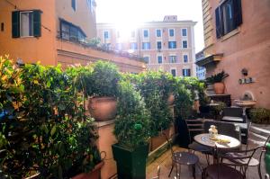 a balcony with tables and potted plants on a building at Hotel Felice in Rome