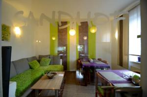 a living room with a green couch and a table at Pension Sandhof in Knittelfeld