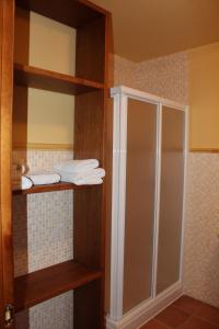 a bathroom with a shower and some towels on shelves at Alojamiento Rural Sierra Luz in Ribatajadilla +34 photos