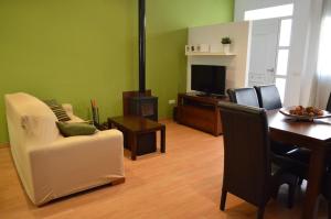 a living room with a table and chairs and a television at Casa Rural La Tramontana in Estivella