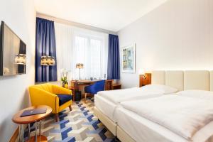 ライプツィヒにあるシーサイド パーク ホテル ライプツィヒのベッド2台とデスクが備わるホテルルームです。