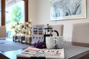 een tafel met een krant, een koffiepot en een tijdschrift bij Villa Lara - 11 in Kouklia