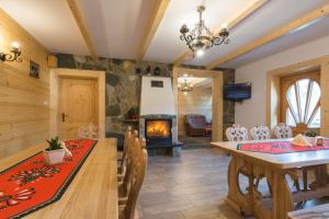 a dining room with a table and a fireplace at Apartamenty u Kukuca in Szczawnica